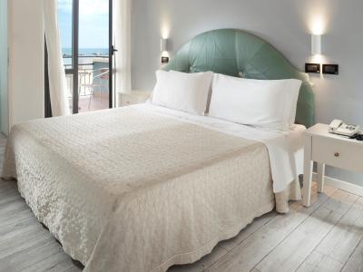 Bright bedroom with a double bed and sea view from the balcony.