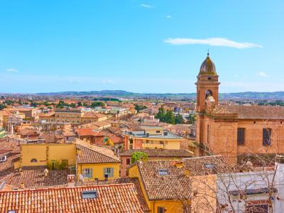 Panoramablick auf eine italienische Stadt mit Dächern und Kirchturm.