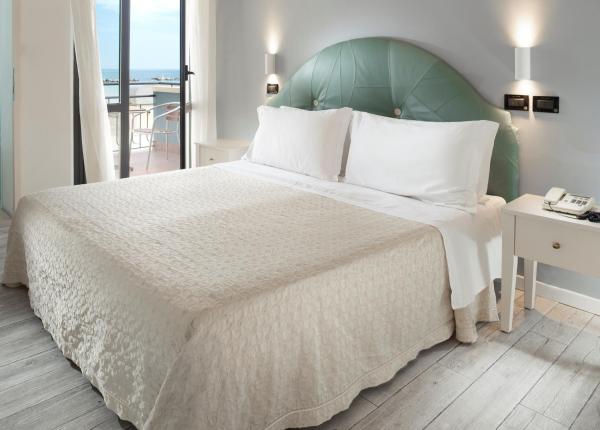 Bright bedroom with a double bed and sea view from the balcony.